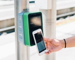 Mobile phone making a payment to a payment reader. ACH could soon become a preferred method of contactless payments.