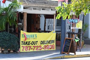 A restaurant banner offering takeout and delivery, one more sign of the pandemic.