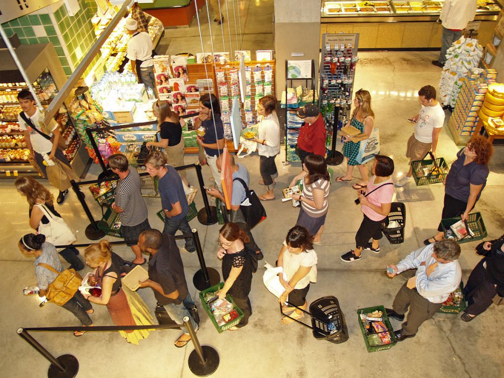 Long line of shoppers at a food store. Returns season will be very busy, so be aware of return fraud.