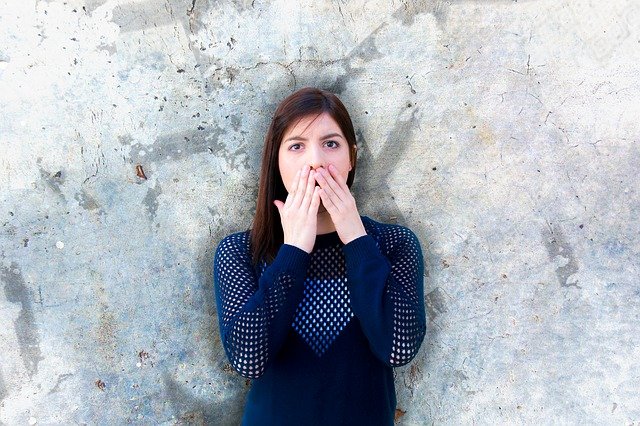 A young woman with both hands over her mouth. What is her body language saying? Monitoring igital body language works much like watching a person's own body language.